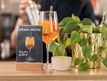 Tischaufsteller an Tresen mit Aperol