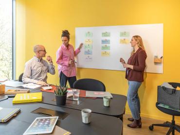 Team arbeitet an Glas-Whiteboard