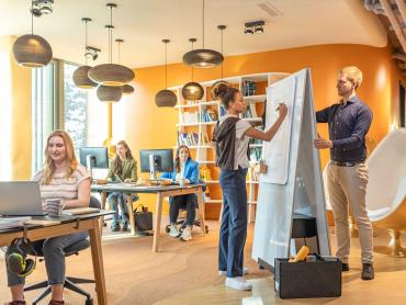 Frau und Mann arbeiten in Open Office an mobilem Whiteboard
