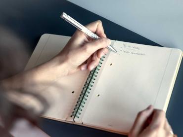 Frau schreibt Notizen in Conceptum Notizblock