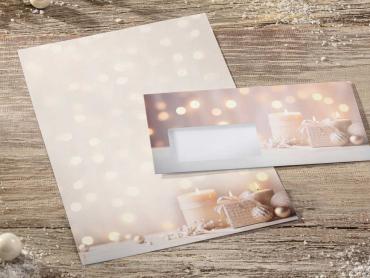 Briefpapier mit beige farbenem Weihnachtsdesign und passendem Briefumschlag auf Holzplatte angeordnet