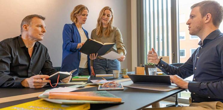 Team arbeitet zusammen an Meetingtisch