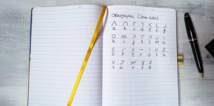Notizbuch mit Stenografie Alphabet