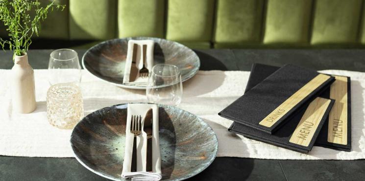 Speisekarten in unterschiedlichen Formaten liegen auf Tisch in Restaurant