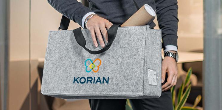 Graue Desk Sharing Bag aus hellem Filz mit aufgedrucktem Firmenlogo.