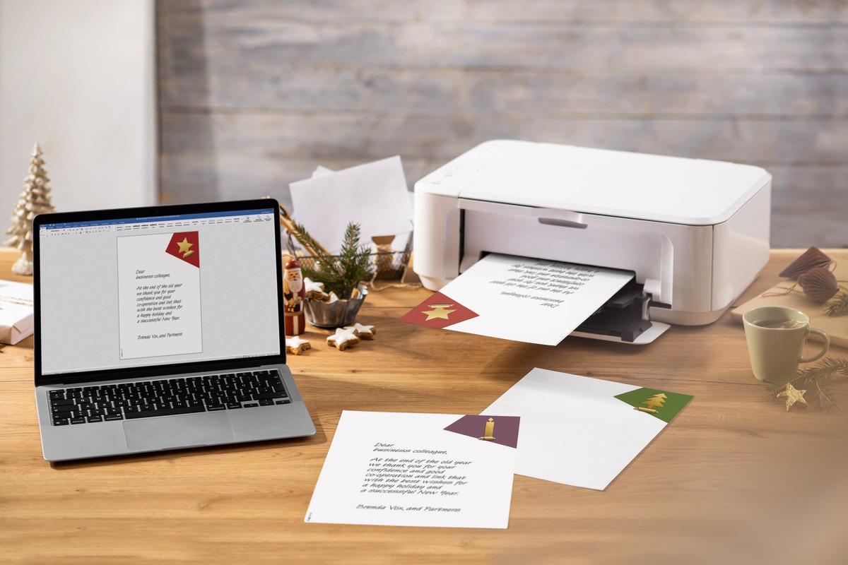 Laptop and printer on table, Christmas cards