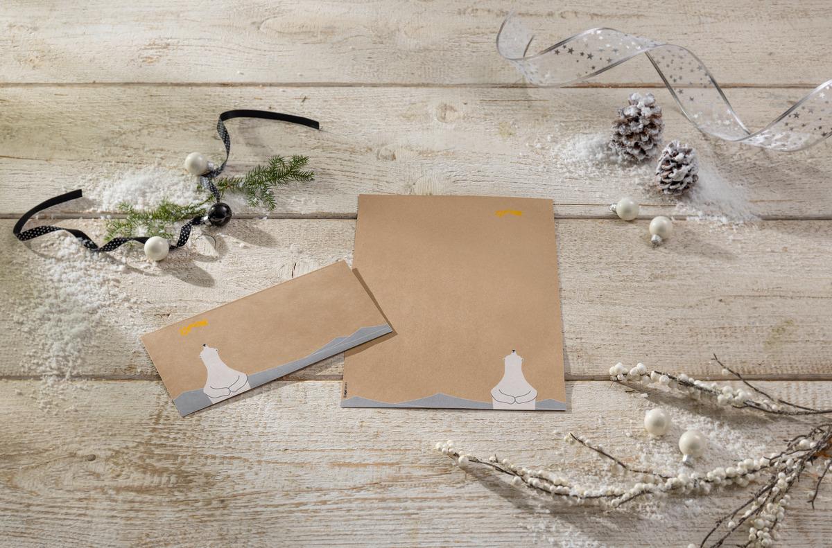 Two brown cards with polar bear illustration surrounded by twigs, bows and pine cones