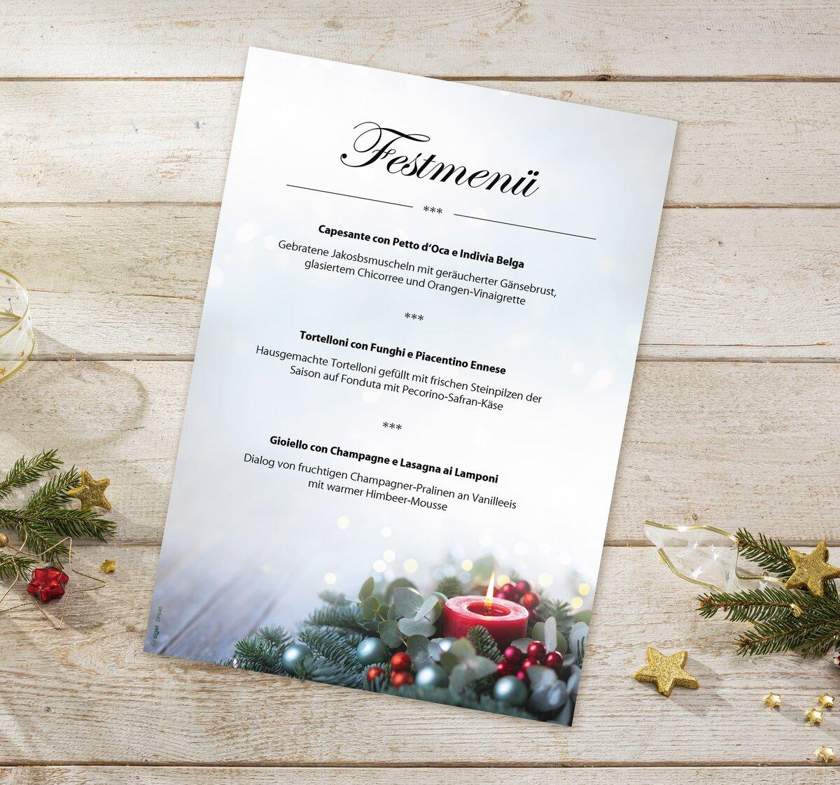 Festive menu on wooden plate, decorated with fir branches and candle