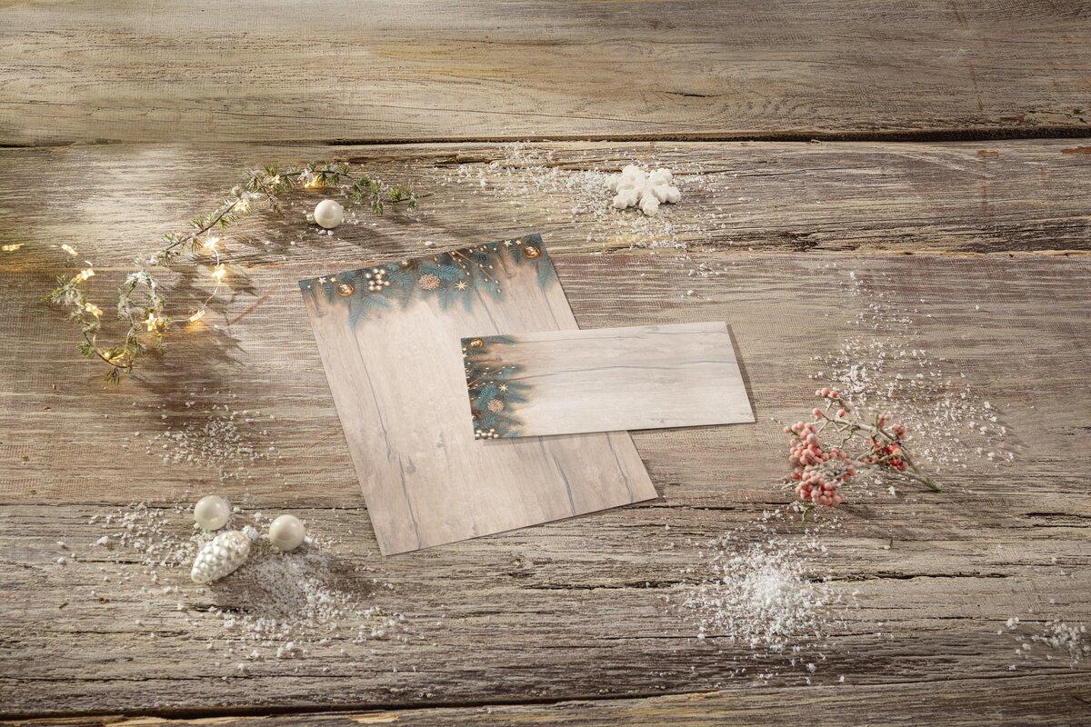 Christmas greeting cards with decoration on wooden background, fairy lights, snowflakes and pearl jewelry frame the scene
