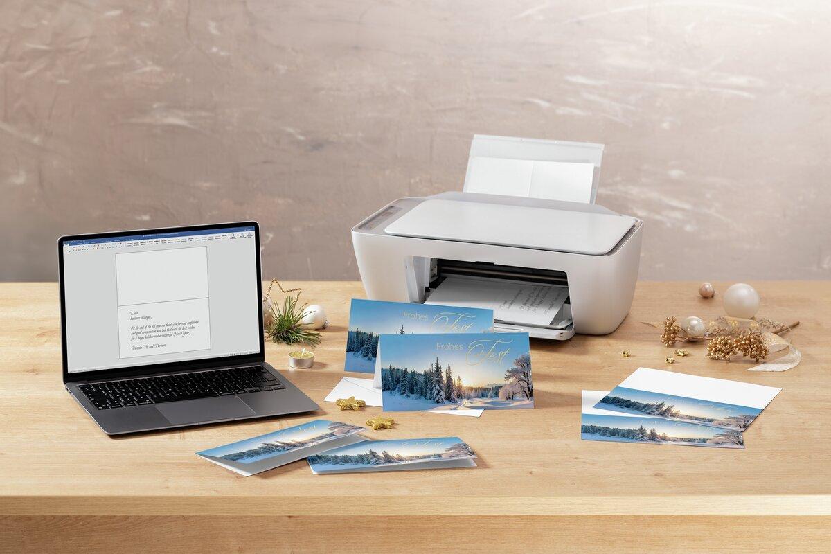 Laptop, printer, Christmas cards on wooden table