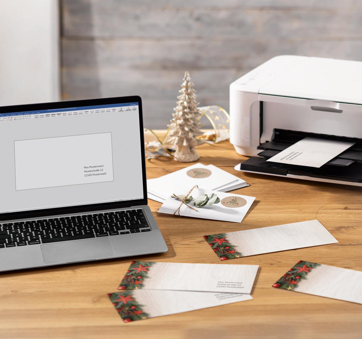 Laptop and printer on wooden table, Christmas cards