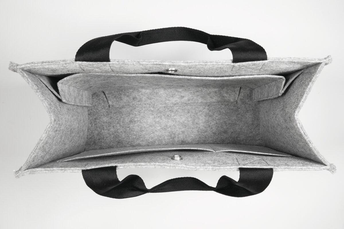 Graue, leere Filztasche von oben Schwarze Griffe