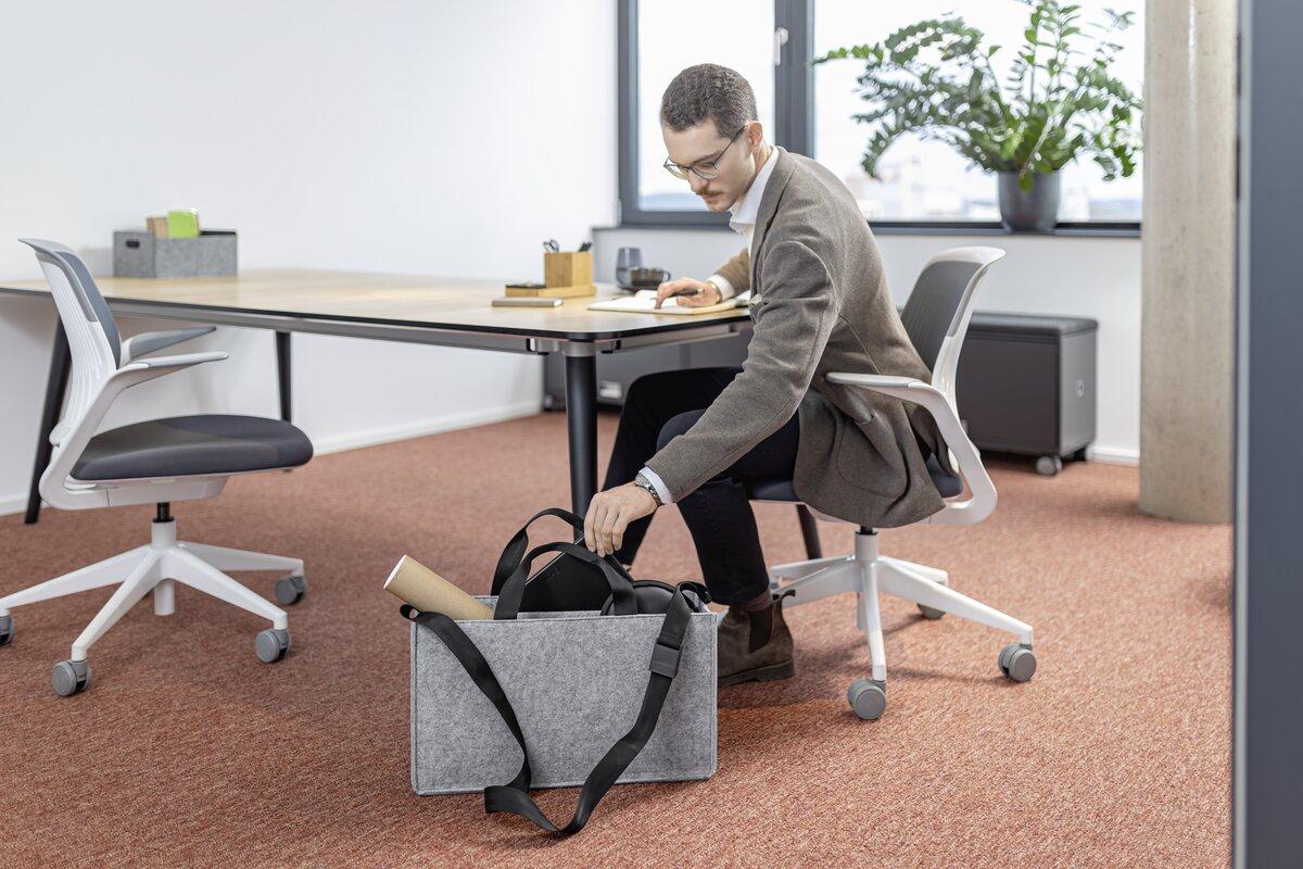 Mann in Büro packt Tasche ein