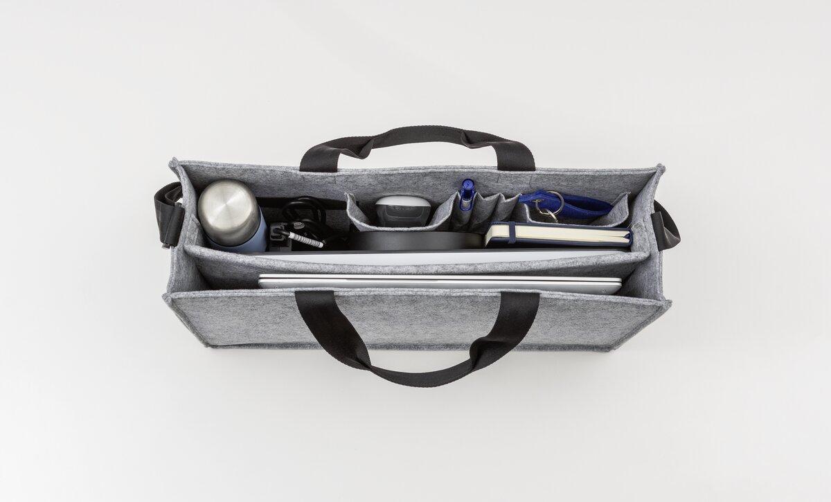 Geöffnete Tasche mit Laptop, Wasserflasche und Notizbuch in Fächern