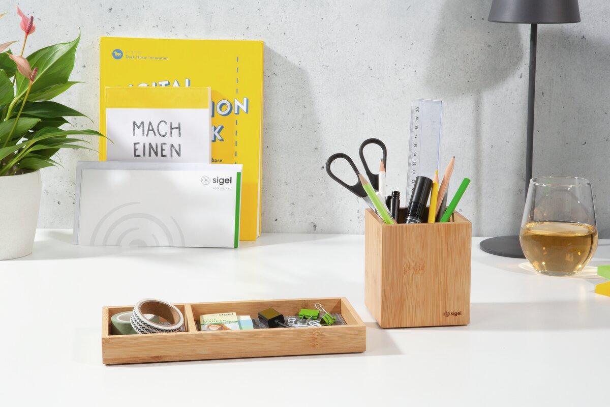 Desk with writing utensils, plants and drinks glass