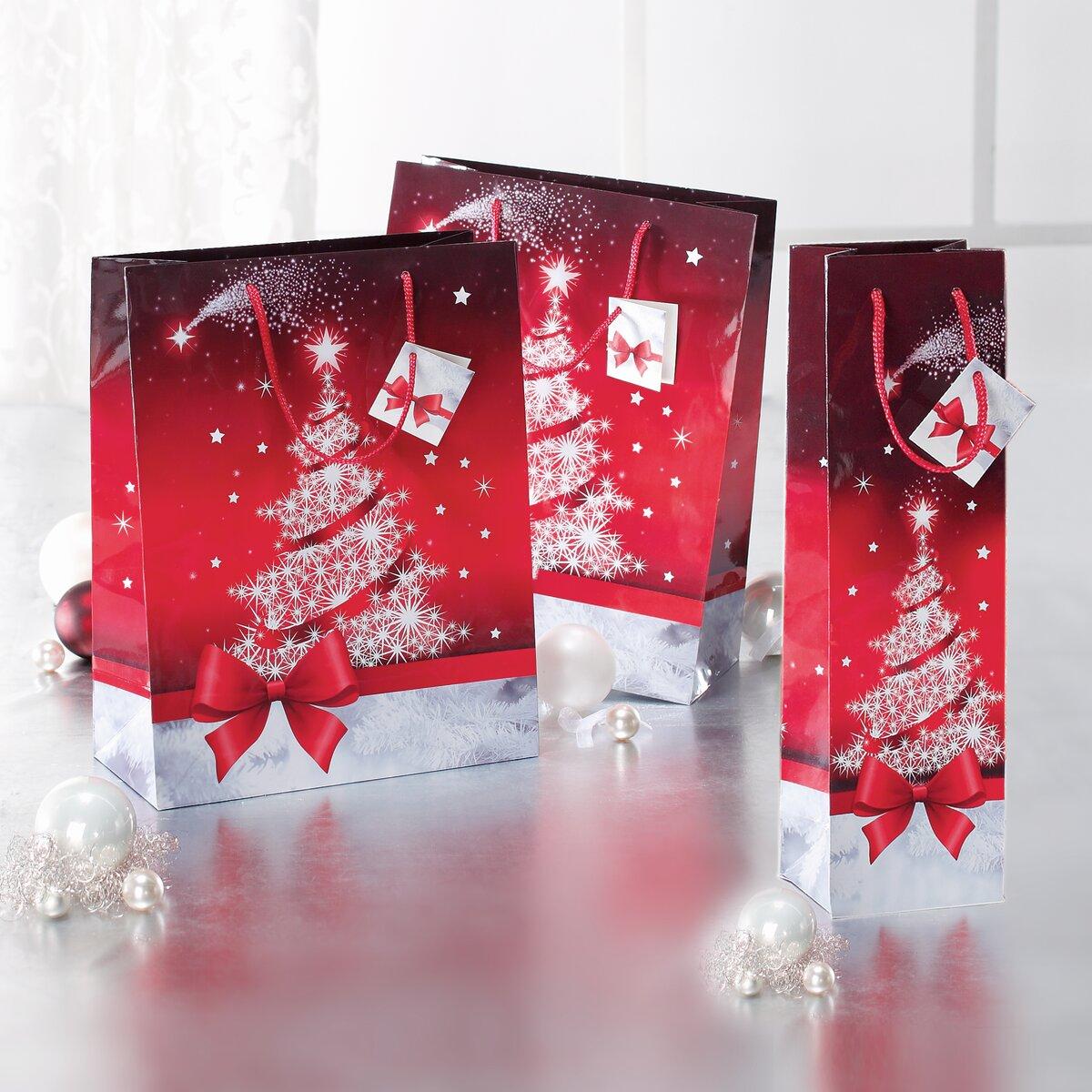 Red gift bags with Christmas tree White baubles in the foreground