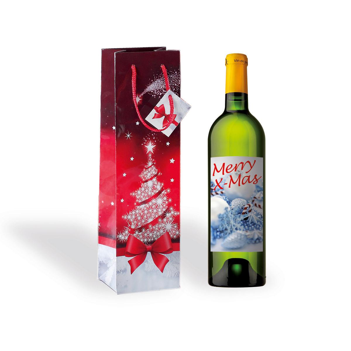 Wine bottle with festive label, next to red gift bag with snowflake tree and bow