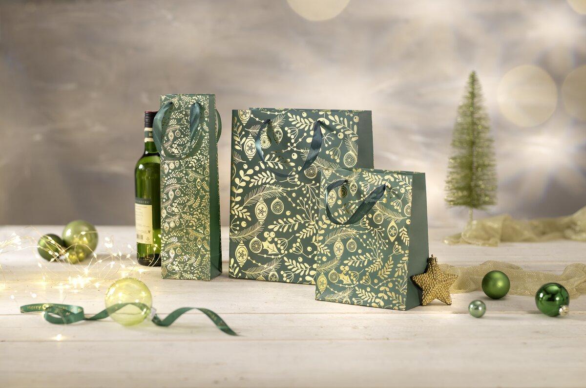 Gift wrapping with gold patterns, Christmas baubles and a wine bottle