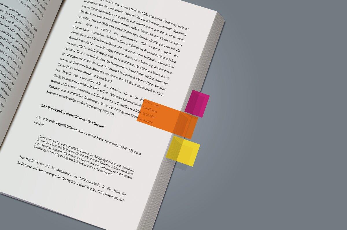 Open book with markings in pink, orange, yellow