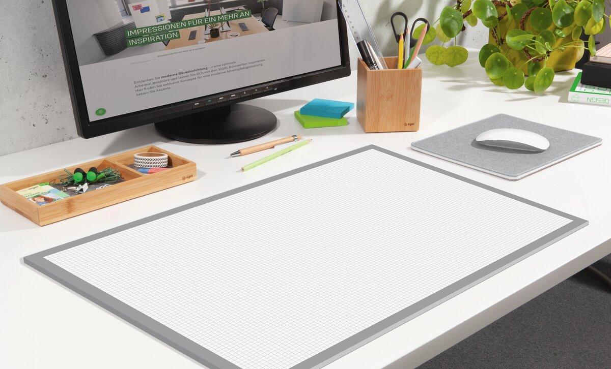 Desk with monitor, writing utensils and plant