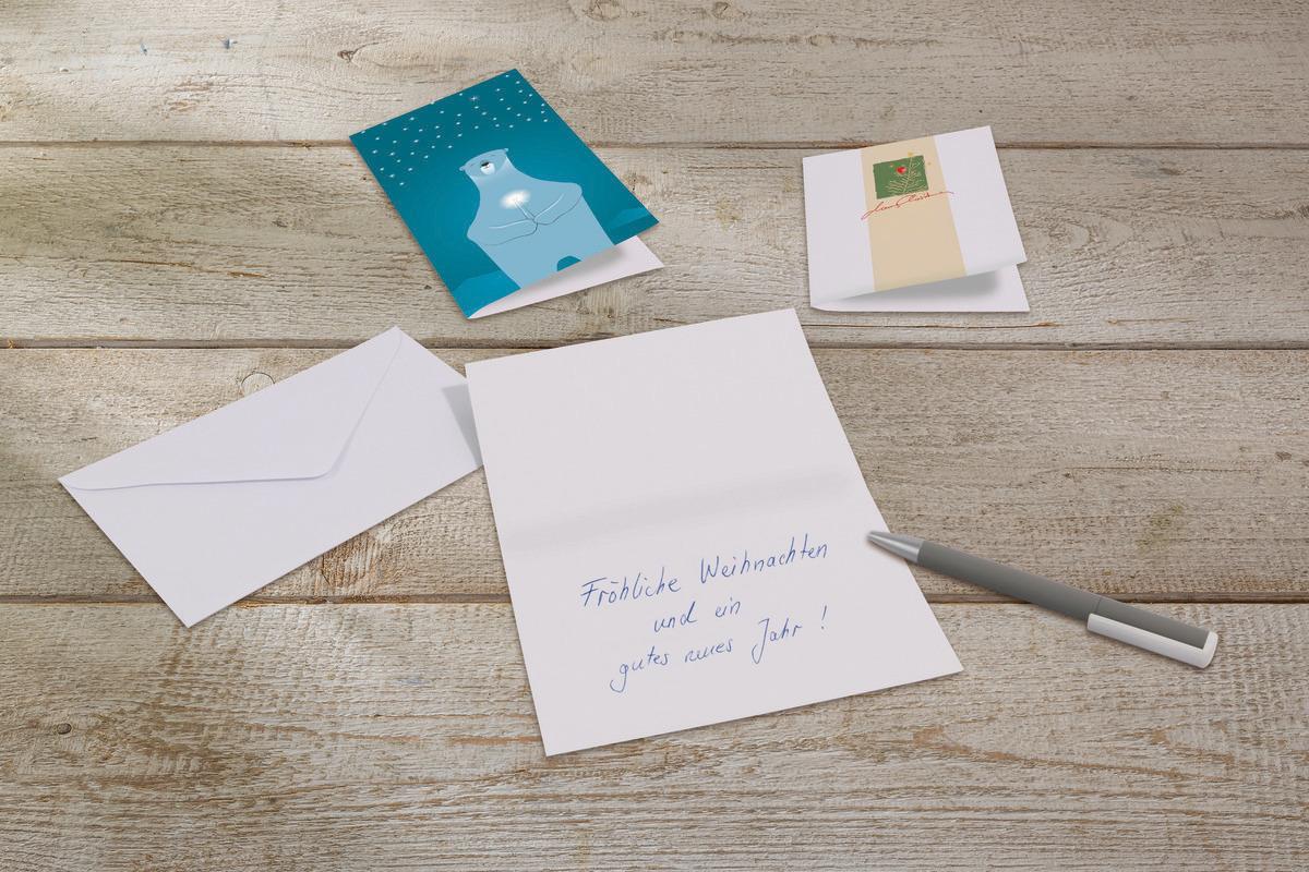 Christmas cards and envelopes on wooden table