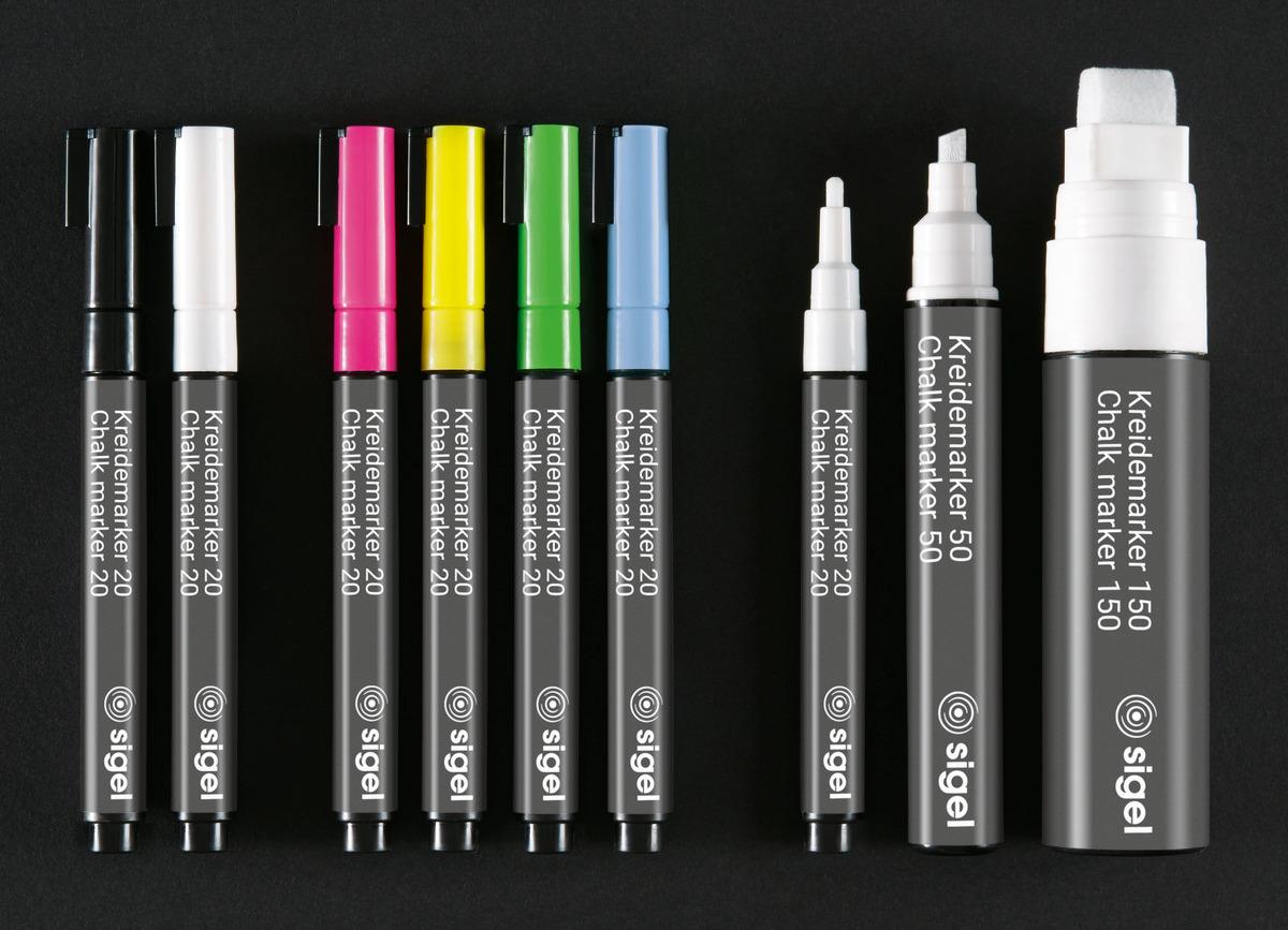 Colorful chalk markers in black, white, pink, yellow, green, blue and various sizes on black background