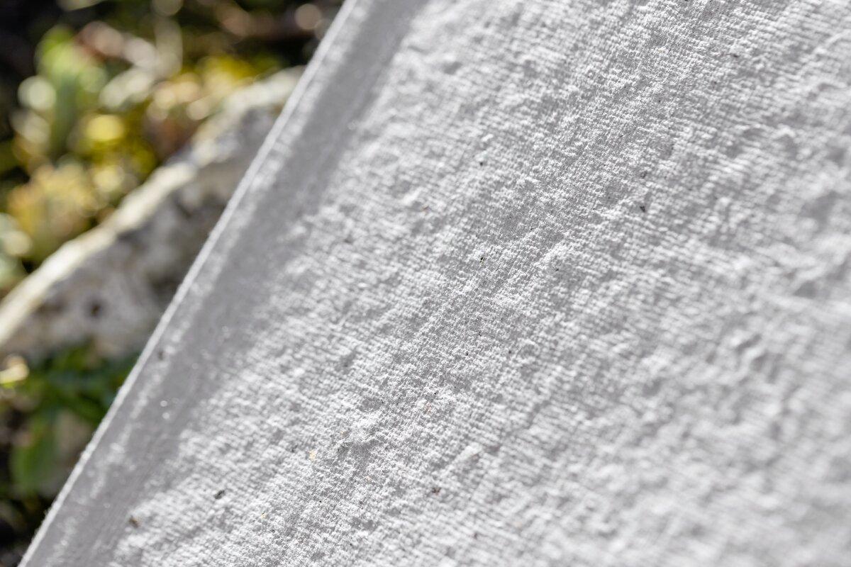 Weiße, strukturierte Leinwand Unscharfer Hintergrund mit Pflanzen