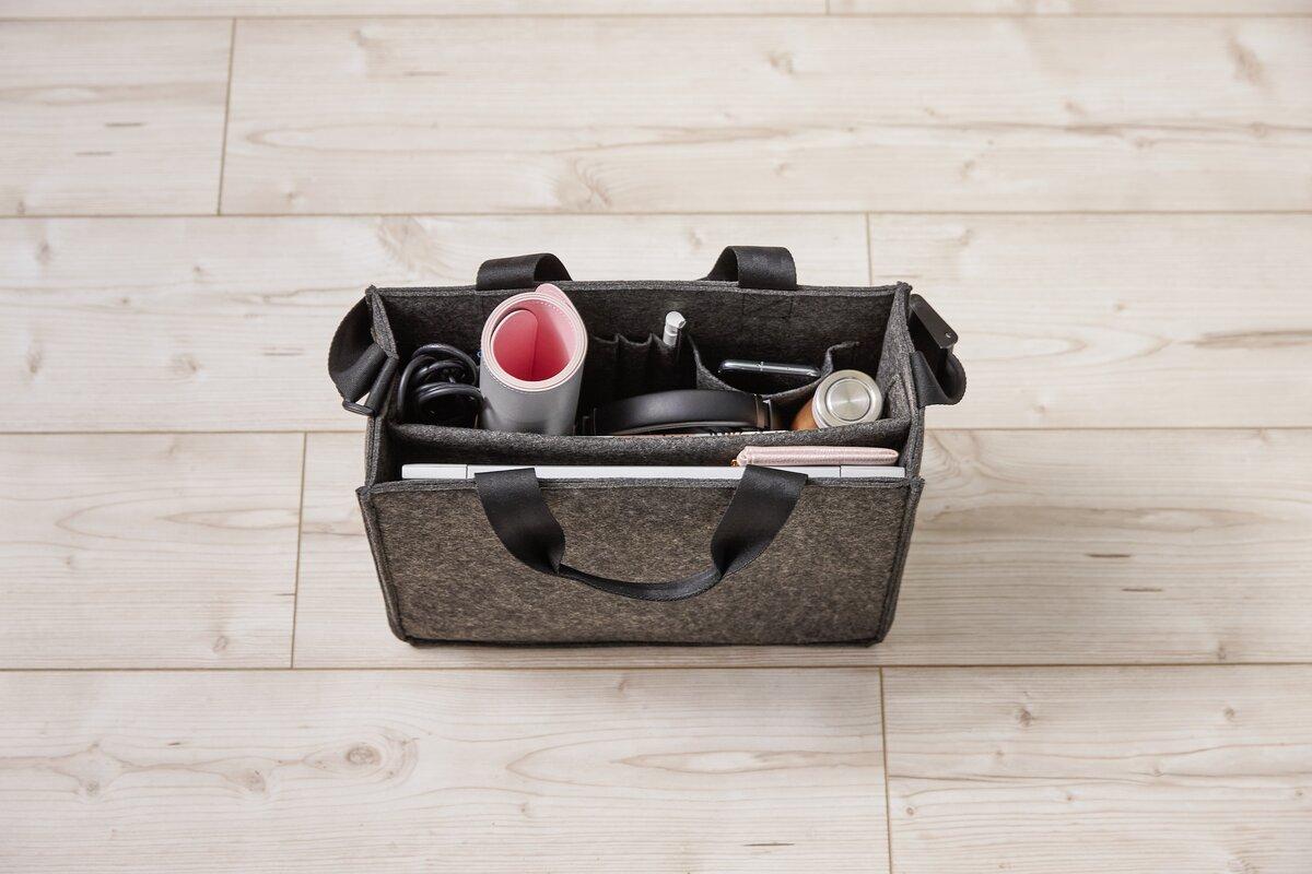 Tasche mit Büroartikeln auf Holzboden