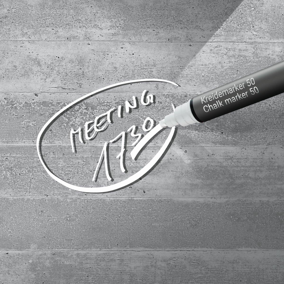 Chalk marker writes meeting 17:30 on concrete wall