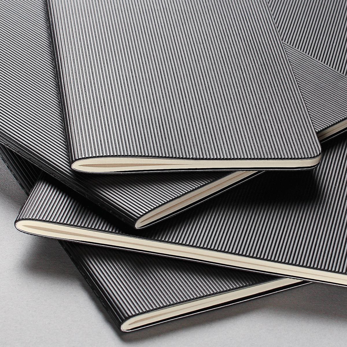 Several black-and-white striped notebooks, some overlapping