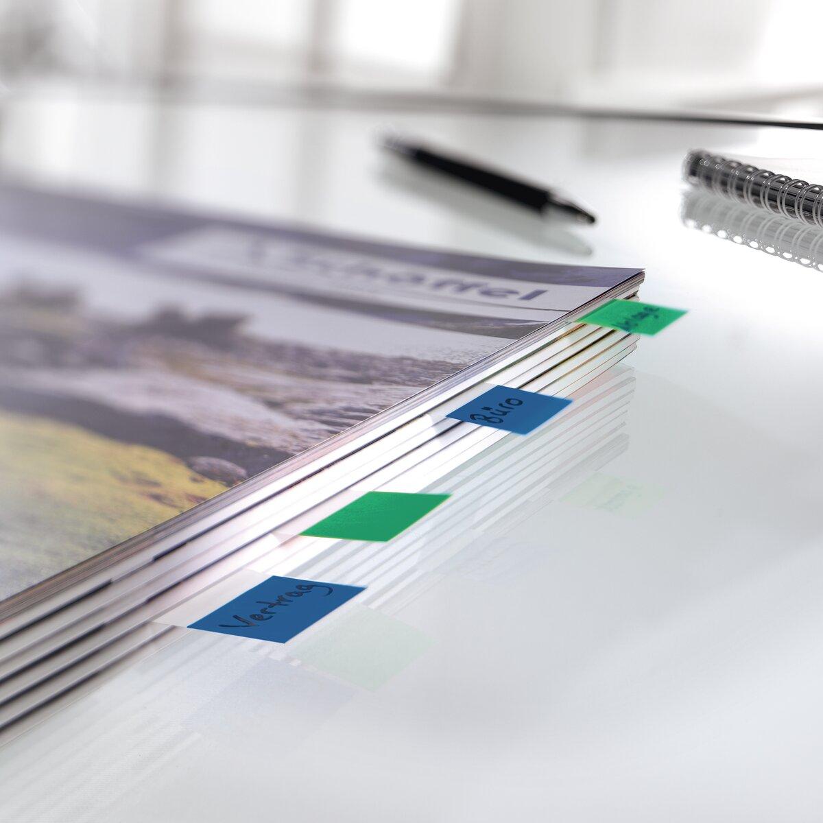 Notebook on table with colorful tabs pen and spiral notebook in background