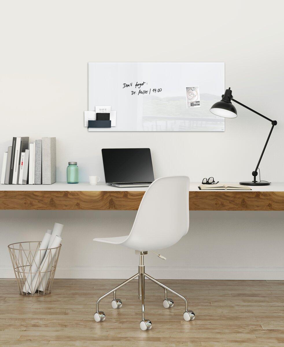 Modern desk with lamp, laptop and whiteboard