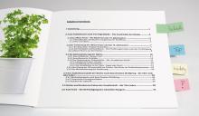 Plant next to book with table of contents, colorful sticky notes on the right