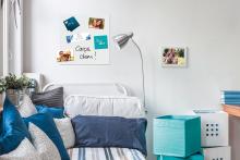 Bed with blue pillows, wall décor and photos
