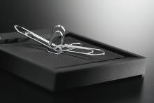 Silver paper clips on black surface