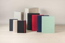 Notizbücher in verschiedenen Farben vor Betonblöcken