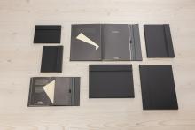 Schwarze Notizbücher auf Holztisch Einige sind geöffnet, Dokumentenfächer sichtbar