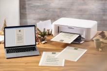 Laptop and printer on wooden desk, printing documents