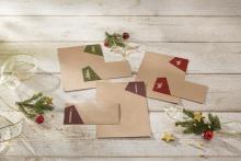 Envelopes with decorations, fir branches and star-shaped ornaments on wood