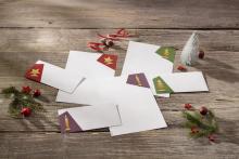 Christmas stationery on wooden table, with decorations such as Christmas tree and candle ornaments