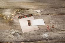 Christmas greeting cards on wooden table Lighted branches and snow decoration