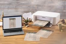 Laptop and printer on table, Christmas card