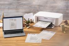 Laptop and printer on desk, Christmas card is being printed