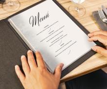 Open menu on table, hands hold it tight
