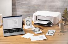 Laptop near printer with greeting cards