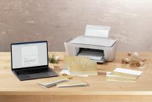 Laptop with letter to printer surrounded by Christmas cards on wooden table
