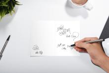 Birthday card with signatures, hand holding pen