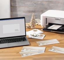 Laptop and printer on table, envelopes and cards