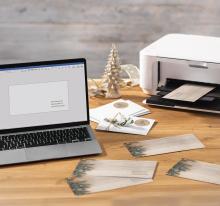 Laptop with label printing, next to printer on wooden table