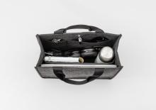 Tasche mit Laptop, Flasche, Kopfhörer und Kabeln von oben